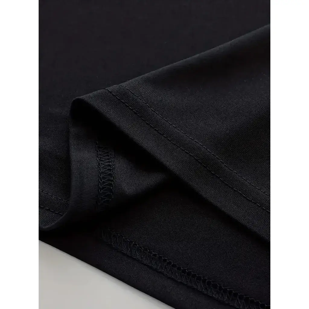 Close-up detalhado da costura reforçada na barra da Camiseta Unissex "Claymore", evidenciando a alta qualidade estrutural e o acabamento premium para os fãs vestirem sua paixão pela guerreira Clare com máximo conforto e durabilidade no dia a dia.